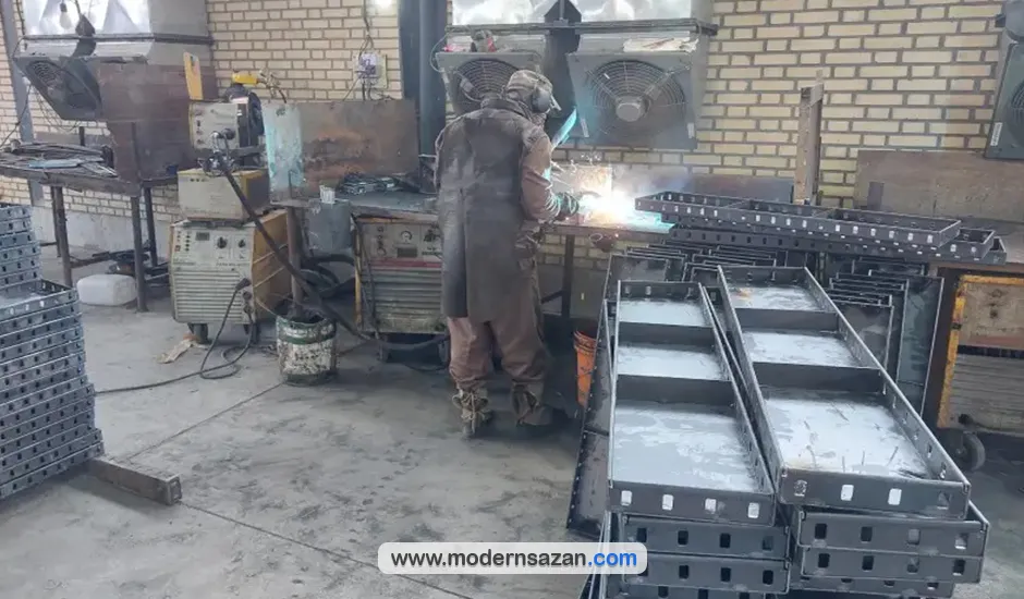 تصویر کارگر در حال جوشکاری پنلهای قالب فلزی بتن